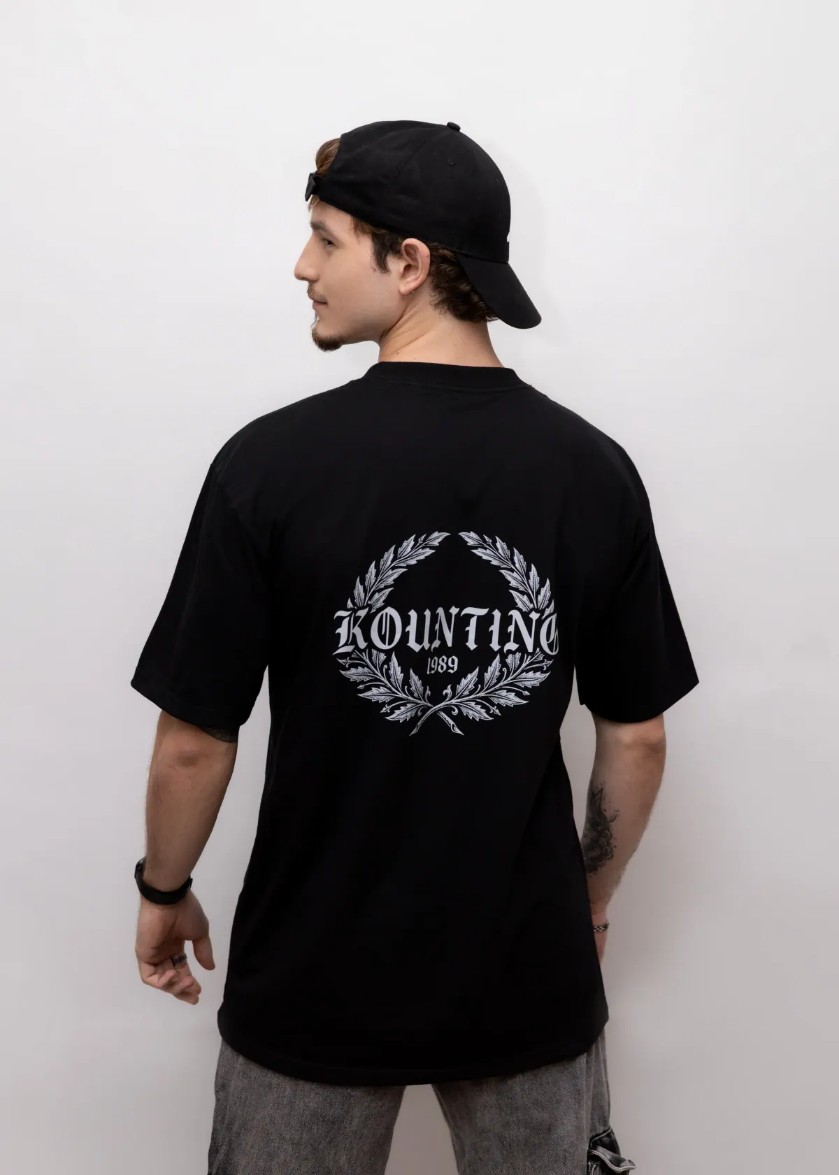 Costas da Camiseta Oversized Essential Emblema preta com emblema da KOUNTING
