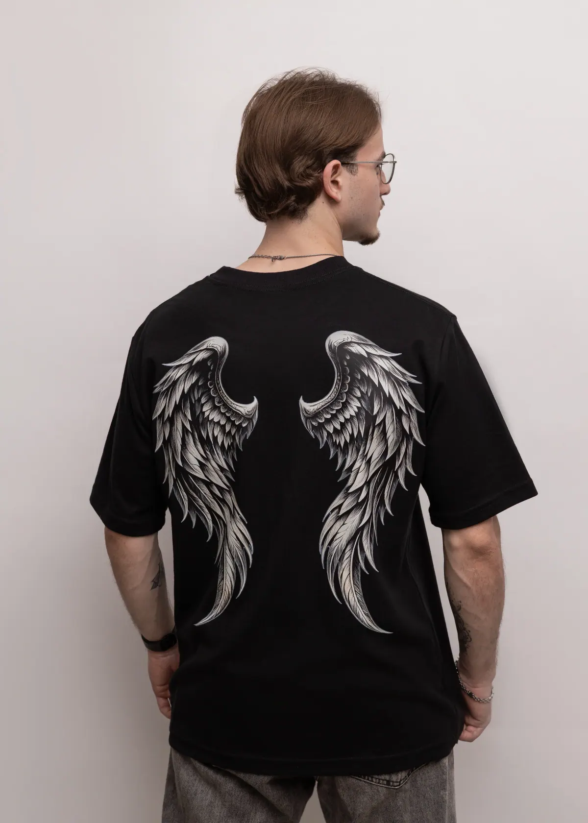 Costas da Camiseta Oversized Premium Asa preta com estampa de asas detalhadas